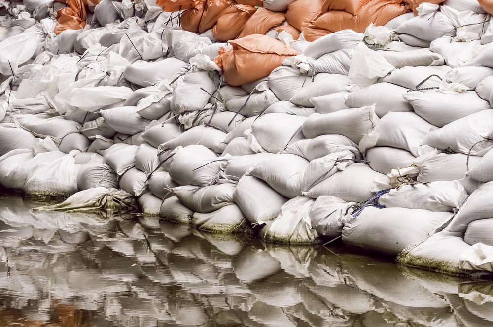Wall of sandbags reflected by large puddle in parking lot near the Illinois River Documentary detail for themes of flood control, emergency response, preparedness